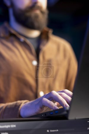 Programador de teletrabajo que utiliza el ordenador portátil para filtrar el tráfico malicioso de los ciberdelincuentes que intentan corromper los datos de la empresa. Administrador de TI que trabaja en notebook, previniendo ataques de malware y phishing