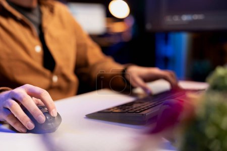 Photo for Man doing software quality assurance using keyboard and mouse, reading source code on computer. System administrator inspecting coding on desktop PC, looking to fix potential issues, close up shot - Royalty Free Image