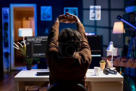 Photo for Programmer stretching body limbs after securing company servers from virus attacks all day. Fatigued IT remote employee relaxing tense muscles at desk after building firewalls protecting data - Royalty Free Image