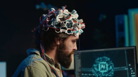IT-Spezialist mit EEG-Headset und Deep-Learning-Technologie, um Gehirn in Computer hochzuladen. Nahaufnahme neurowissenschaftlicher Geräte, die von Menschen verwendet werden, die Bewusstsein in den Cyberspace transferieren, Kamera A