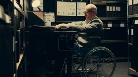 Paralyzed senior inspector reviewing classified case records in incident room, gathering intelligence for private investigation. Wheelchair user with limited mobility accessing databases. Camera B.