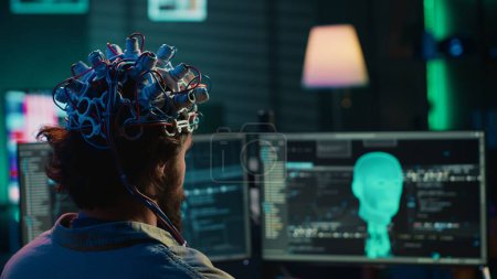 Développeur avec casque EEG sur la programmation du transfert de cerveau dans le monde virtuel de l'ordinateur, devenant un avec l'IA. Transhumaniste utilisant la technologie neuroscientifique pour transcender les limitations physiques, caméra Un gros plan