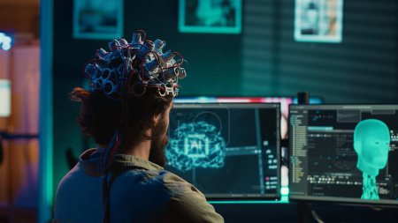 Engineer with EEG headset on programming brain transfer into computer virtual world, merging with artificial intelligence. Transhumanist using neuroscience to gain digital soul, camera A
