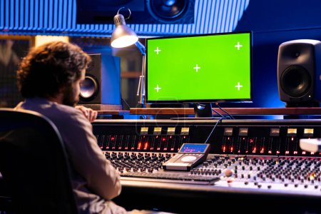 Sound engineer working with isolated display in studio control room, pushing buttons and sliders to produce beats. Audio technician creating music by editing tracks in post production.