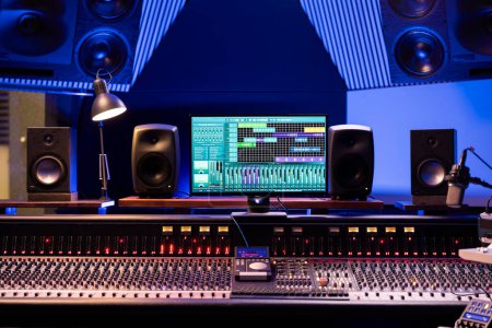 Photo for Empty professional studio used in music industry for producing tracks, mixing console and technical equipment in control room. Electronic panel board with sliders and buttons, daw software. - Royalty Free Image