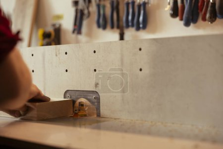 Maquinista CNC que opera moldeadora de husillos para crear una carpintería a medida de alta calidad para el proyecto encargado por el cliente. Carpintero realizando tareas en el moldeador de madera, conformación y corte de materiales