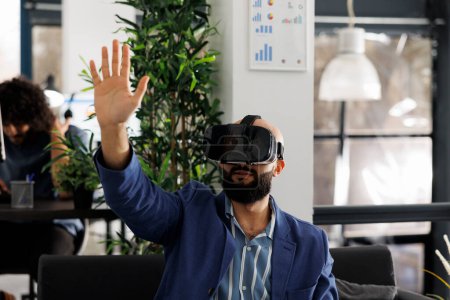Téléchargez les photos : Homme d'affaires en réalité virtuelle casque de travail dans le bureau de démarrage d'entreprise. Employé de l'entreprise explorant métaverse et remue-méninges dans des lunettes vr dans l'espace de coworking d'entreprise - en image libre de droit