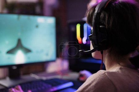 Photo for Woman watching videogame gameplay footage uploaded online by professional streamer. Gamer sitting at home enjoying day off from work looking up game info before deciding to purchase it - Royalty Free Image
