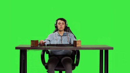 Woman being excited about winning online gaming championship, playing video games on computer sitting at desk. Gamer having fun celebrating her success and victory, greenscreen backdrop. Camera B.