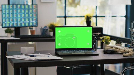 Konzentrieren Sie sich auf den isolierten Bildschirm-Laptop auf dem Firmenschreibtisch mit Computer-Desktop im verschwommenen Hintergrund, der Börsendaten zeigt. Chroma Schlüssel Notebook und Handelsplattform auf PC-Bildschirm im Hintergrund angezeigt