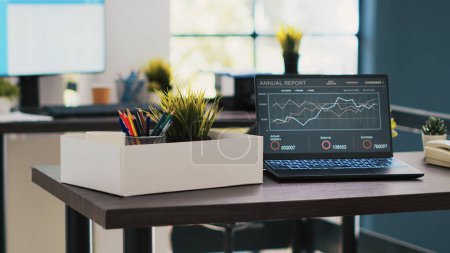 Business forecasting graphs showing profits on laptop in empty office. Economic annual revenue statistics report on notebook screen in accounting department office with no people in