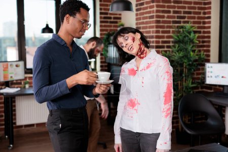 Woman starving for coffee in african american manager hands, needing it to maintain productivity, being worked to death. Tired employee looking like zombie, thirsty for caffeine in office
