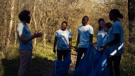 Team von Aktivisten sammelt Plastikmüll auf, um Müll zu recyceln und zu sammeln und reinigt die natürliche Umwelt des Waldes für den Naturschutz. Menschen, die sich freiwillig für die Rettung des Planeten einsetzen. Kamera B.