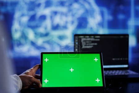Admin writes code on green screen tablet to visualize artificial intelligence neural networks using augmented reality. High tech workspace supervisor runs AI script on chrome key device