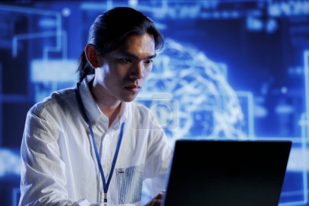 Ingénieur certifié dans le centre de données utilise l'intelligence artificielle informatique simulant le cerveau humain grâce à des algorithmes d'auto-apprentissage. Spécialiste compétent avec ordinateur portable travaillant avec des réseaux neuronaux profonds AI