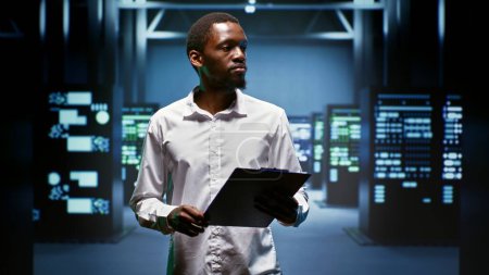 African american engineer doing maintenance in data center providing vast computing resources and storage, enabling artificial intelligence to process massive datasets for training and inference