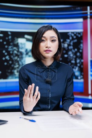 Photo for Reporter on night talk show presenting events during entertainment and media segment in newsroom. Woman journalist discussing about breaking news reportage with exclusive headlines. - Royalty Free Image