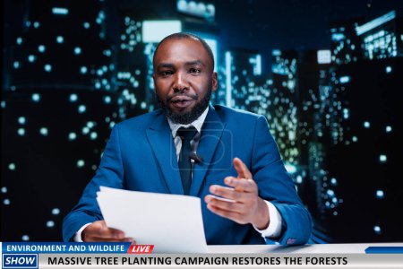 Journalist reveals environment program to plant trees and help preserve forests, breaking news on night show. Presenter talking about saving the planet and protecting natural regions, world events.