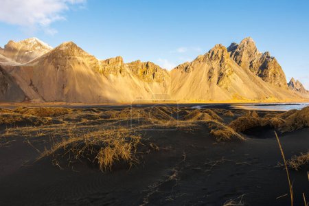 Téléchargez les photos : La grâce du nord le long du littoral et des montagnes glorieuses du Vestrahorn en Islande. Célèbre littoral Stokksnes avec plage de glace et environnement scandinave, horizon arctique naturel avec des collines rocheuses. - en image libre de droit