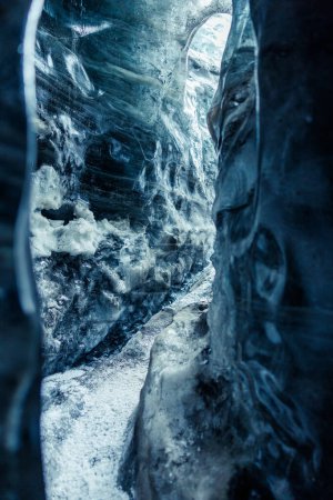 Beautiful ice formations in vatnajokull crevasse, massive blue icy rocks of melting frozen structure. Global warming affecting icelandic glaciers and icebergs, destroying ice caves.