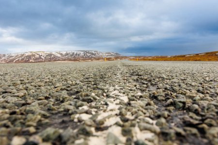 Foto de Paisaje islandés y largo camino en un paisaje escandinavo con caminos vacíos, tierras congeladas y campos de hielo. Espectacular vista panorámica del campo ártico, cumbres nevadas. - Imagen libre de derechos