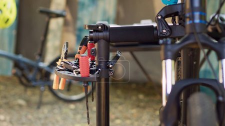 Téléchargez les photos : Un assortiment d'équipements professionnels disposés sur un stand de réparation prêt pour l'entretien du vélo. Zoom avant de différents outils de travail pour la réparation et la restauration de vélos dans la cour. - en image libre de droit
