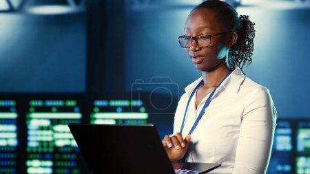 Woman walking through high tech facility server rows providing computing resources for different workloads. Admin reviewing data center supercomputers tasked with solving complex operations, close up