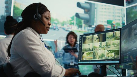 African american operator gathers gps coordinates and data for the government database, monitoring cars in traffic via surveillance CCTV security systems. Real time radar recordings. Camera B.