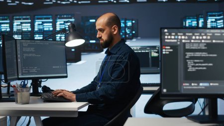 Computer scientist programming in high tech facility with server rows providing computing resources for different workloads. IT programmer overseeing supercomputers tasked with solving data operations
