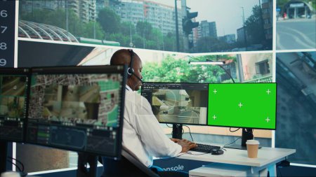 Employé afro-américain utilisant un système de sécurité CCTV et un écran de simulation, surveillant le trafic à travers des vidéos de surveillance vidéo en temps réel dans la salle d'observation. Expert assure la sécurité publique. Caméra B.