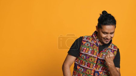 Photo for Portrait of narcissistic cheerful indian man celebrating and bragging, showing arrogance. Satisfied person boasting about achievement, cheering and gesticulating, studio background, camera A - Royalty Free Image