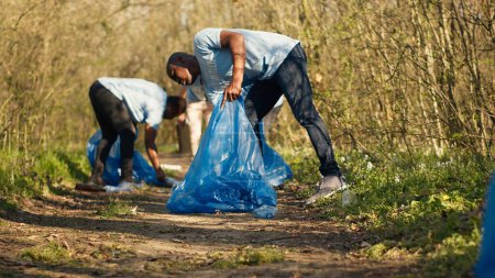 Menschen, die Müll und Plastikflaschen aus dem Waldgebiet holen, die Natur schützen und ehrenamtlich arbeiten. Aktivisten säubern den Wald, recyceln Abfall. Kamera A.