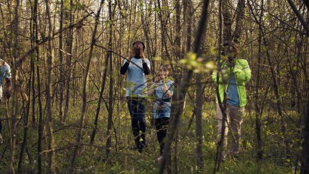 Grupo de voluntarios salvavidas en busca de una persona desaparecida, llamando a su nombre en el bosque y pasando por los árboles para seguir los pasos. Escuadrón de rescate en busca de una víctima perdida. Cámara B.