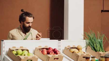 Vegan man in zero waste supermarket shopping for organic chemicals free produce. Customer buying vegetables in local neighborhood grocery shop with no single use plastics policy
