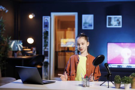 Kid content creator using professional recording equipment to film vlog channel intro for online streaming platforms. Young media star greets fanbase, presenting today video topic