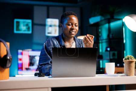 Smiling woman using credit card for online purchases, making internet transactions while shopping from her apartment. Black lady buying goods, e commerce internet banking, and spending money.