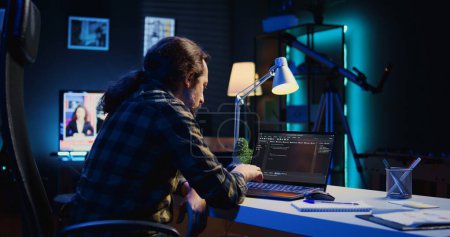 Erfahrene Programmierer schreiben Code auf Laptop-Bildschirm, während in der Wohnung Büro mit Java-Programmiersprachen. Entwickler, der von zu Hause aus an der Behebung von Datenbankfehlern arbeitet, Kamera B