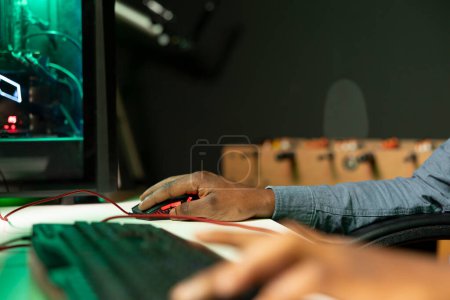 Gamer mit Tastatur und Maus, um FPS Singleplayer-Videospiel auf dem PC zu spielen, genießen Sie die Freizeit. Person in der Wohnung in der Nacht mit High-Tech-Computer-Peripherie, um Feinde zu zerstören, Nahaufnahme