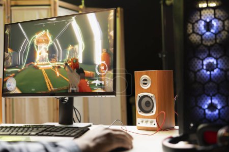 Mann in angezündeter Wohnung spielt Ego-Shooter-Videospiel auf Desktop-PC am Computer-Schreibtisch, Abwicklung. BIPOC-Spieler tritt in Internet-Multiplayer-FPS gegen Feinde an