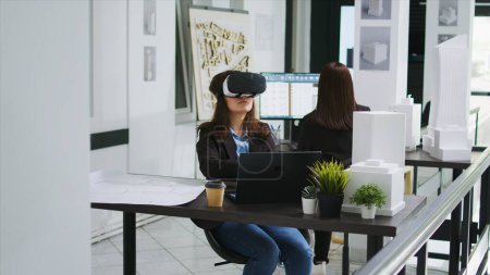 Woman architect working with vr glasses in startup office, modeling floor plan or house blueprint using metaverse artificial intelligence. Industrial engineer developing architectural lines.