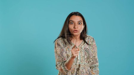 Upset indian person fighting with friend, doing scolding gesturing, isolated over studio backdrop. Annoyed woman arguing with opponent during discussion, doing admonishing hand gestures, camera A