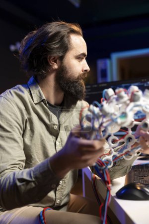 Informatiker mit EEG-Headset, um seinen Geist in den Computer zu laden und so Unsterblichkeit zu erlangen. Softwareentwickler in Wohnung experimentiert mit Bewusstseinstransfer in den Cyberspace