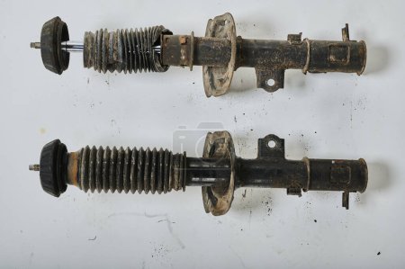 Photo for Old shock absorber struts removed from the car, used parts, shot against a homogeneous background - Royalty Free Image