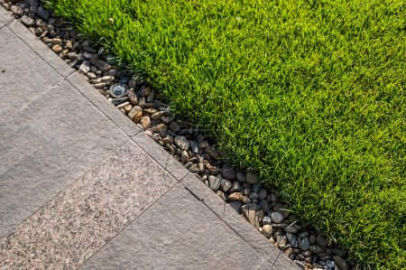 Foto de Losas de piedra de granito y césped de hierba verde en el diseño del paisaje, elemento de decoración de jardín primer plano - Imagen libre de derechos