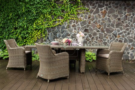 outdoor made of rattan furniture with a served table and chairs on the veranda