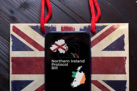 Northern Ireland Protocol bill concept: a smartphone on a plastic bag over a wooden table