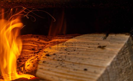 Foto de La trayectoria de las chispas de un tronco ardiendo en una estufa de pueblo - Imagen libre de derechos