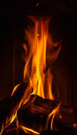 Foto de Primer plano de la quema de troncos con partículas de hollín y chispas del fuego en la chimenea - Imagen libre de derechos