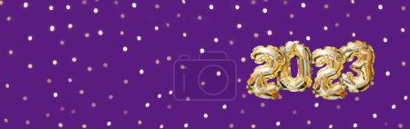 Foto de Helio número globo de oro del año 2023. Guirnalda festiva brillante con bokeh sobre fondo púrpura. Feliz Año Nuevo tarjeta de felicitación - Imagen libre de derechos
