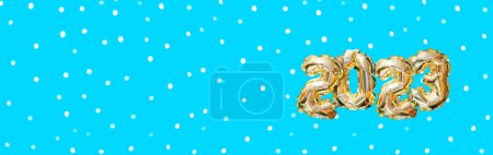 Foto de Helio número globo de oro del año 2023. Guirnalda festiva brillante con bokeh sobre fondo azul. Feliz año nuevo banner - Imagen libre de derechos